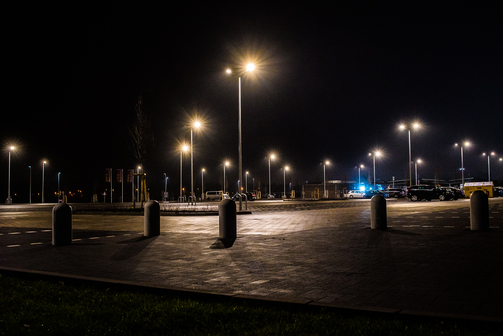 Parkplatz mit Pollern und Laternen bei Nacht