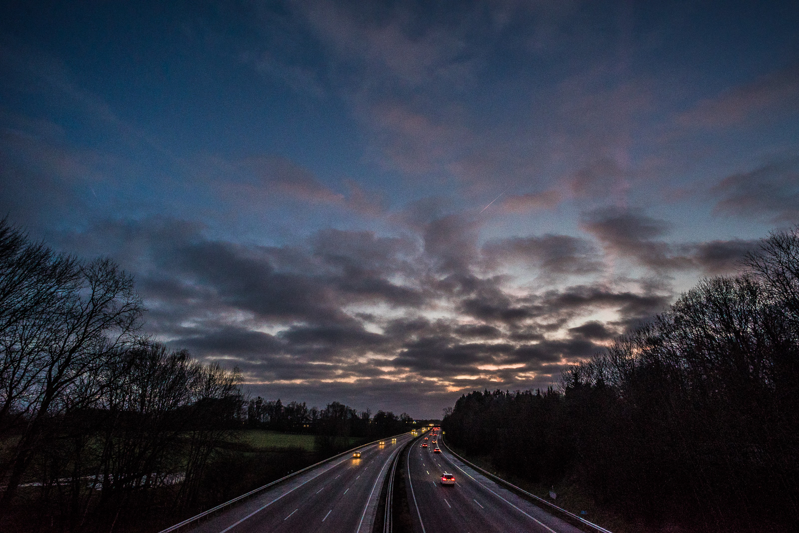 Blick von der Brücke auf die Autobahn, Abendhimmel mit dramatischen Wolken