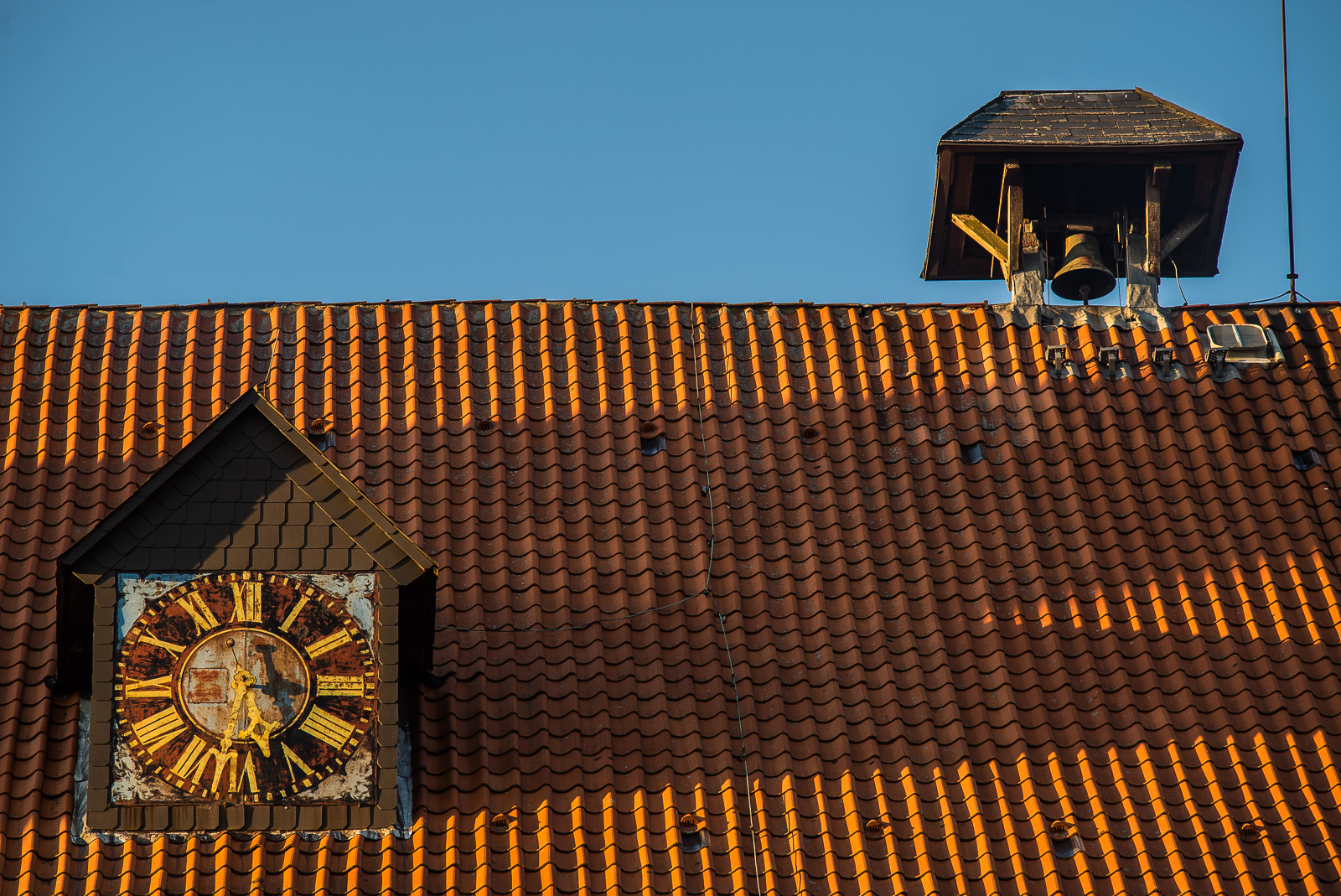 Backstein-Dom von Bardowick: Dach-Ausschnitt mit Uhr (kurz nach halb sechs) und einzelner Glocke oben auf dem First