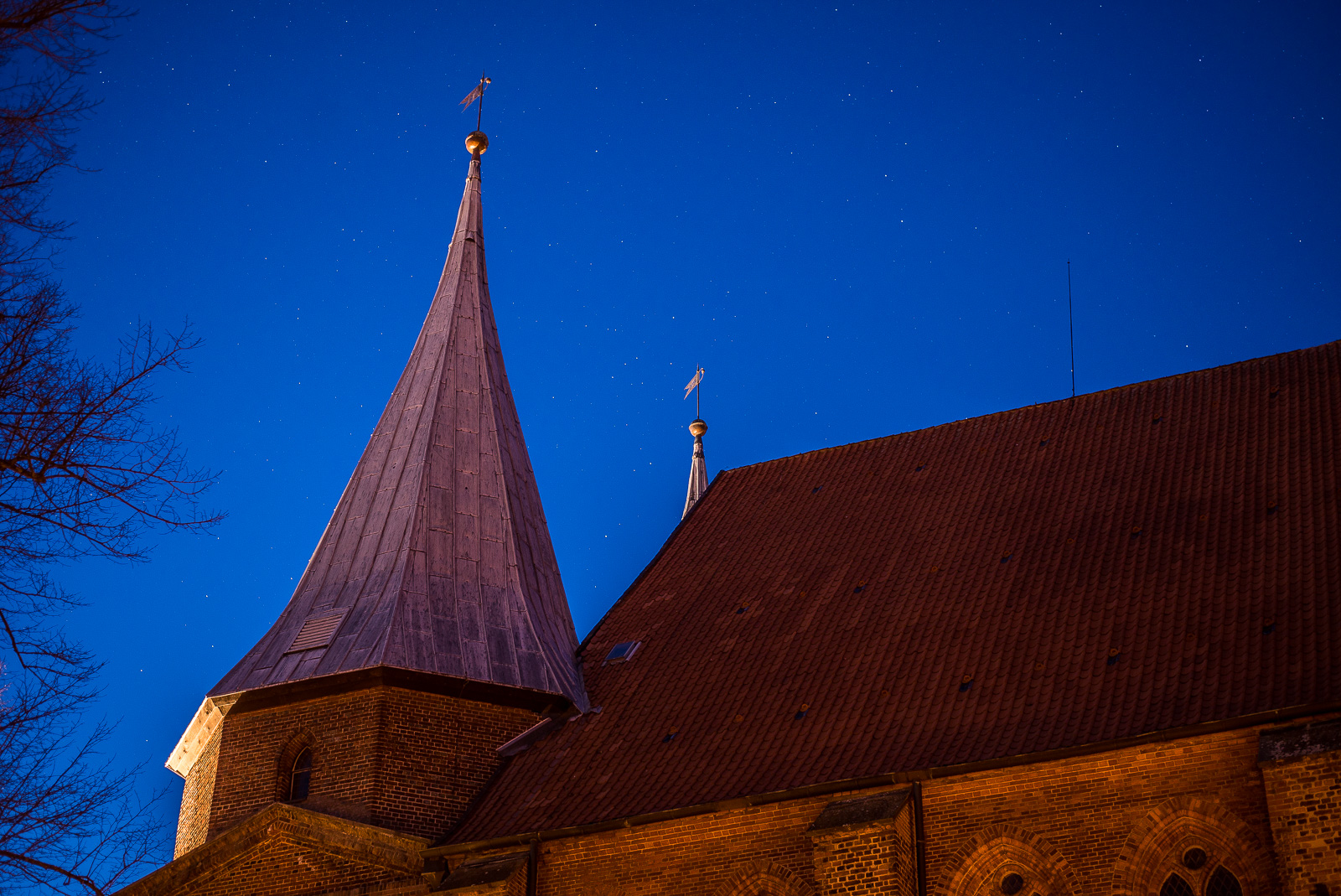 Backstein-Dom von Bardowick: Seitenansicht eines Spitzturms vor dem Nachthimmel mit vielen Sternen