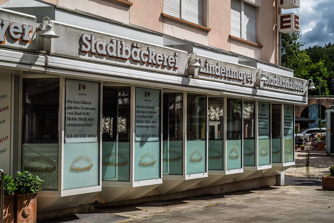 Fassade einer geschlossenen Bäckerei mit Vermietungs-Annonce in jedem Fenster