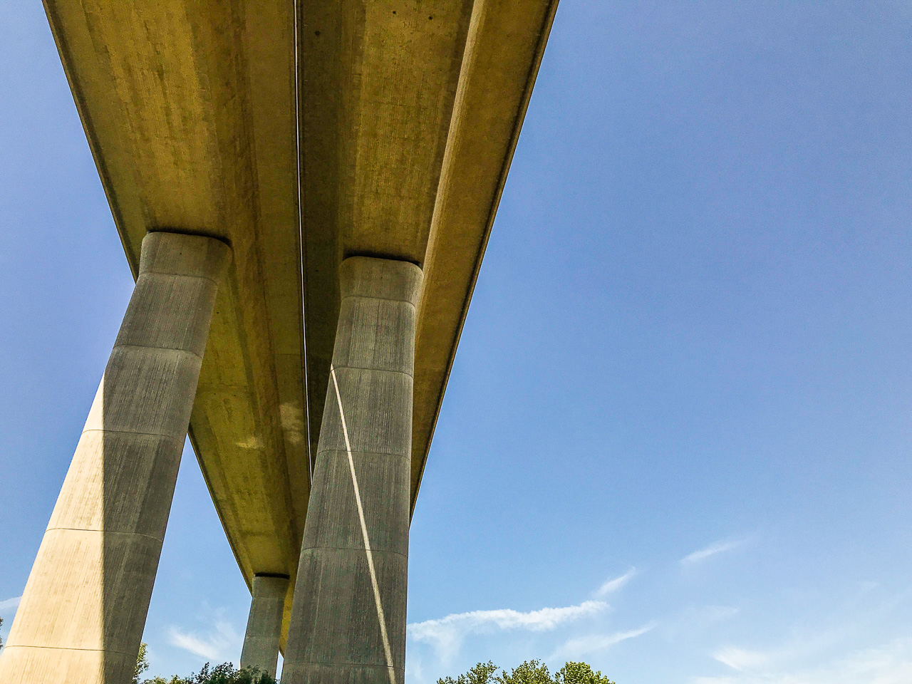 Eine moderne Beton-Brücke von unten gegen blauen Himmel