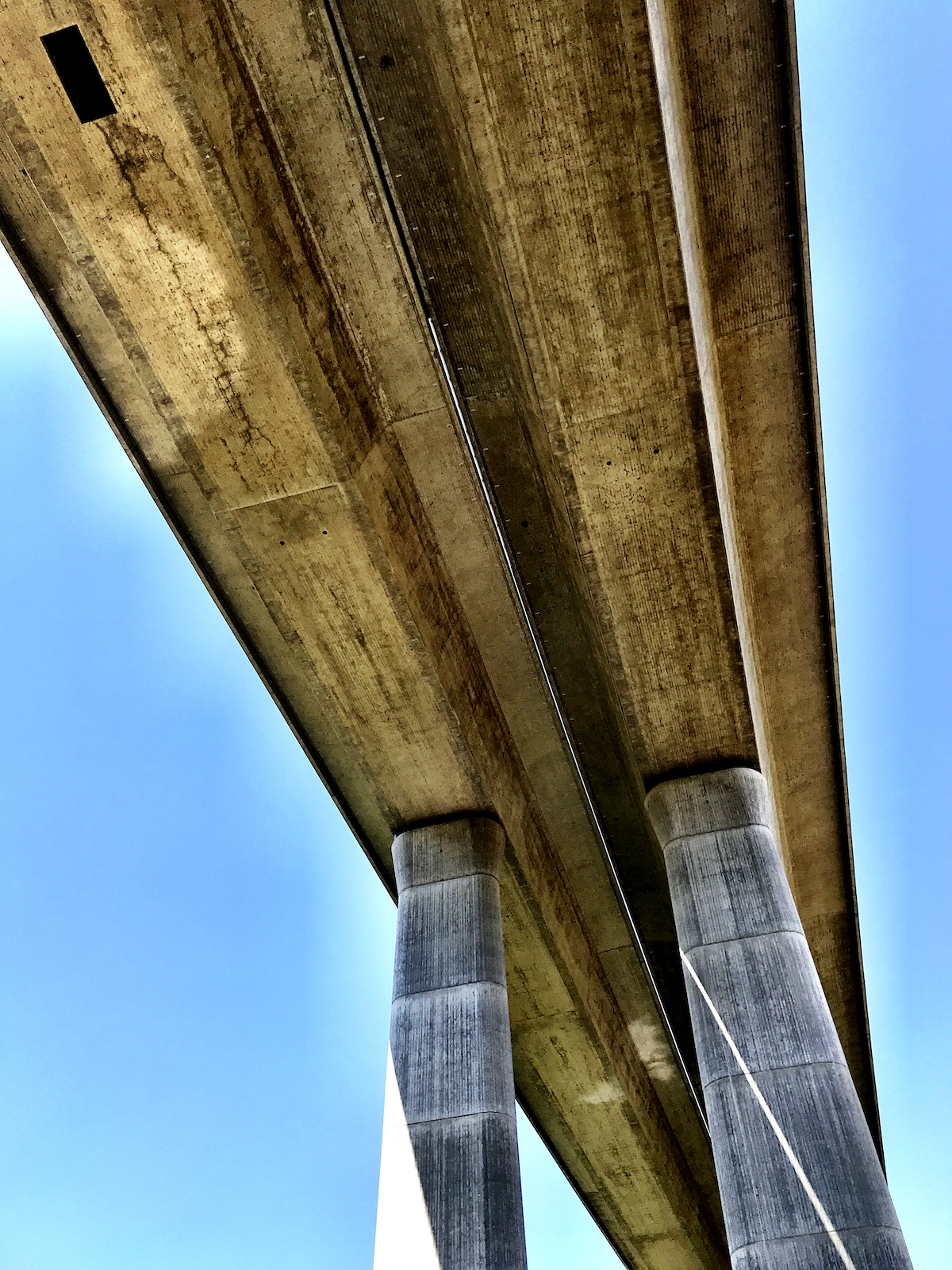 eine Autobahnbrücke von unten, erkennbar bei starker Sonneneinstrahlung