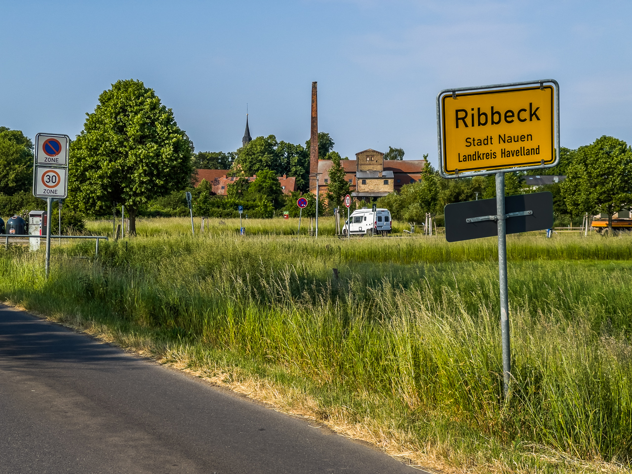 Ansicht eines kleinen, offensichtlich älteren Dorfs im Grünen, vorn OrtsEingangsSchild "Ribbeck Stadt Nauen Landkreis Havelland"