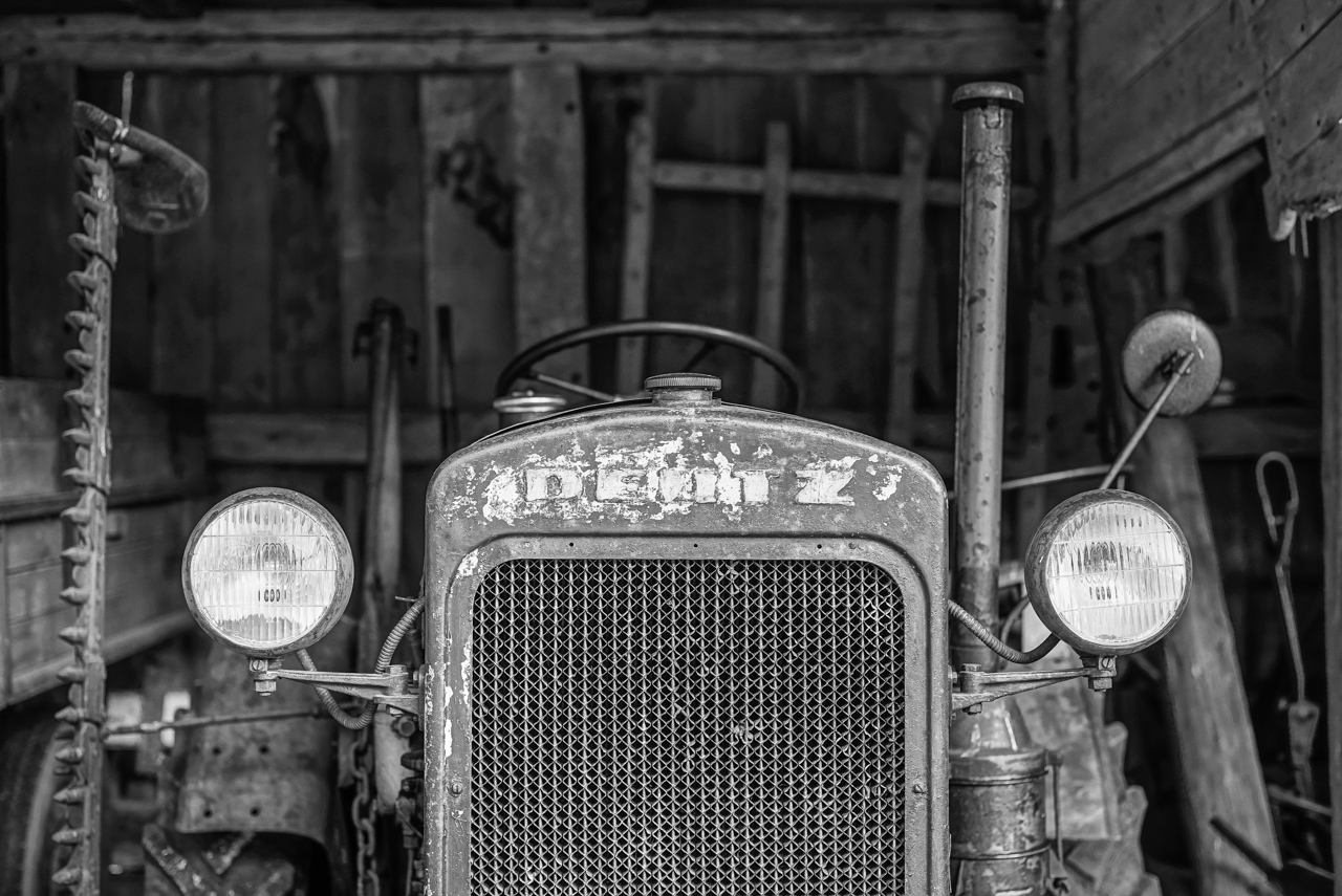 Alter Deutz-Traktor in einer dunklen Scheune, SW-Foto