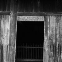 TürÖffnung eines alten HolzHauses, der InnenRaum ist dunkel, fast schwarz
