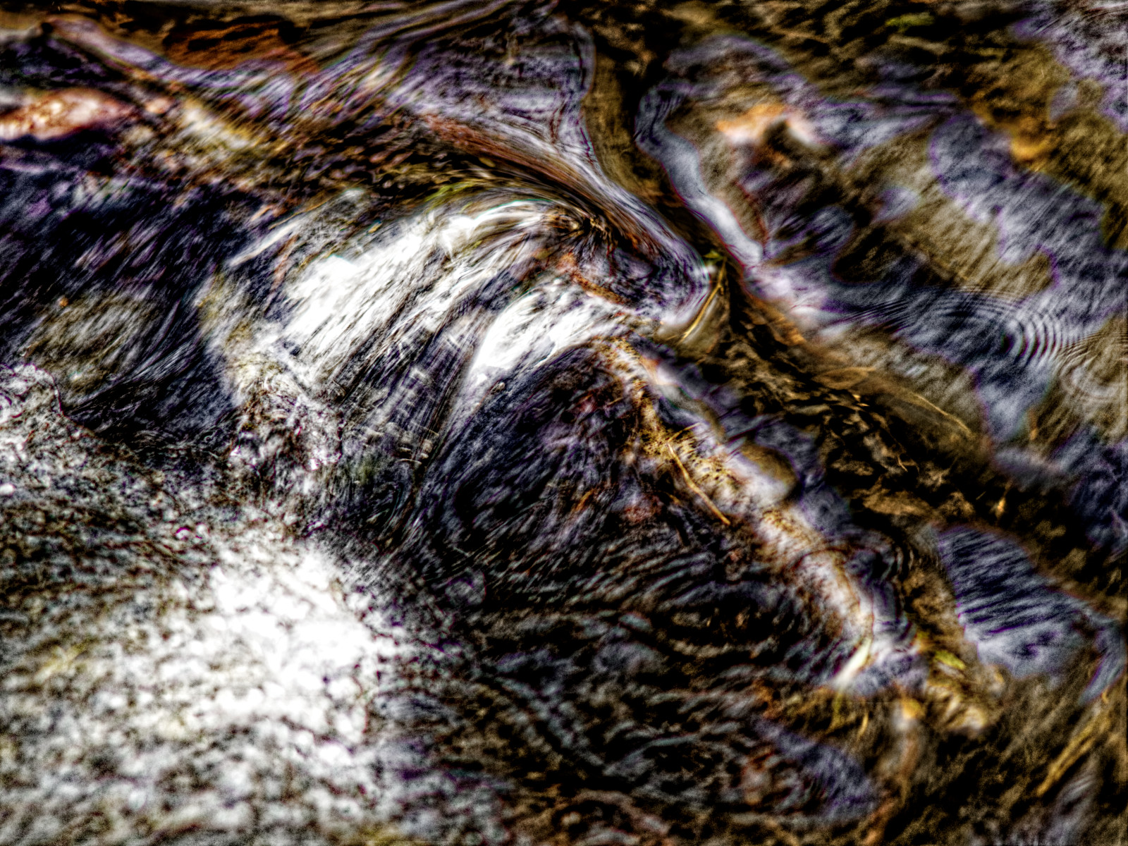 Stromschnelle in einem Bach als Detail-Foto. Kontrastreiches Bild, in dem sich scharfe und weiche Bereiche überlagern.